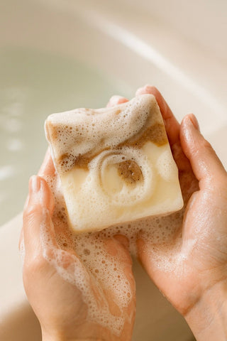 Vetiver Cleanse natural soap with creamy lather in hands